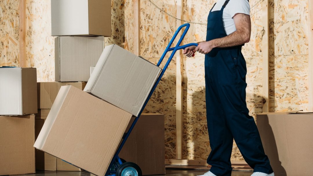 delivery-man-carrying-boxes-on-hand-truck.jpg